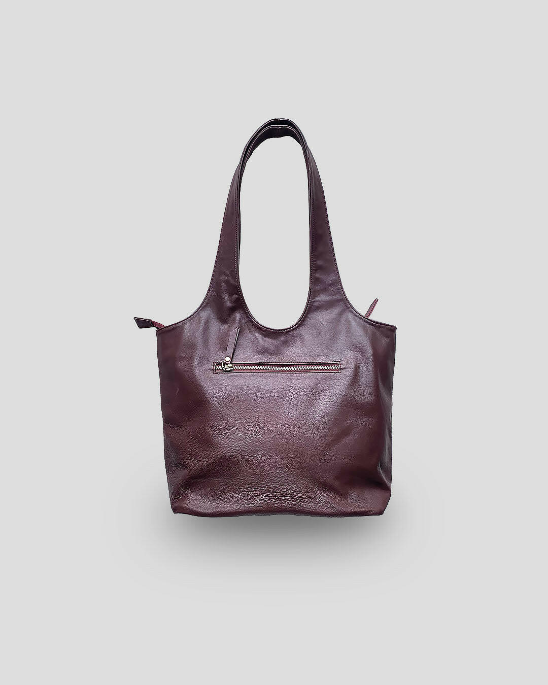 A brown leather handbag with a structured design and a zipper closure at the top.