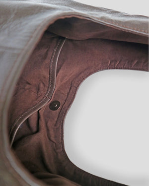 Pouch Close-up of a brown leather product with a button