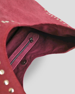 Close-up of a navya suede shoulder bag with a zipper detail.